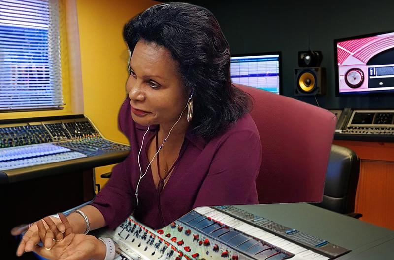 a woman sitting at a desk with a sound board